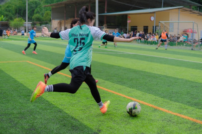 Fussballspielerin, die gerade zu einem Pass auf das Goal ausholt.